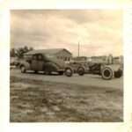 An old photo of a car and a tractor featuring drag racing.