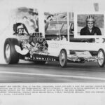 A photo of a man engaged in drag racing while driving a powerful drag car.