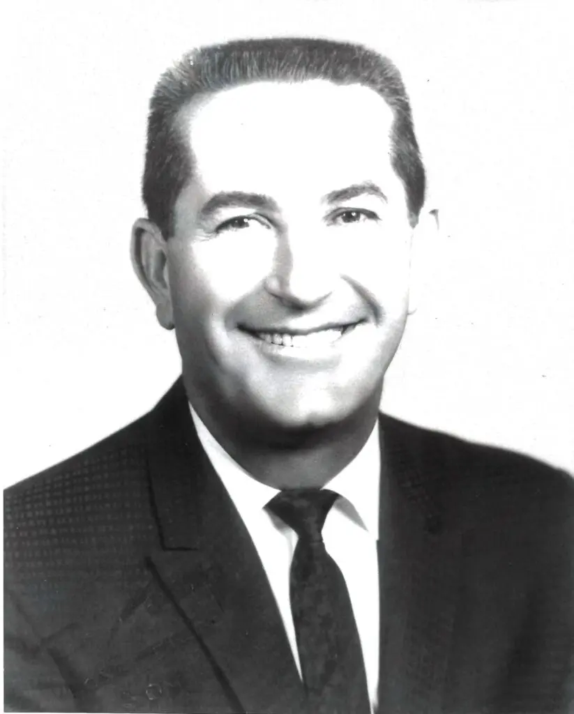 A black and white photo of a man in a suit and tie exuding elegance and sophistication.