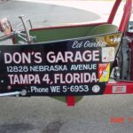 A red and black car featuring a bold sign that says Don's Garage, exuding the vibrant atmosphere of Tampa, Florida.