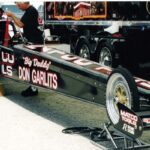 A man is working on a drag car for drag racing.