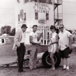 A group of people standing next to a drag racing car.