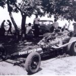 An old black and white photo of a drag racing race car.