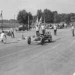 An old photo of a drag racing car on a track.