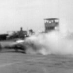 A black and white photo capturing the thrilling essence of drag racing as smoke billows from a high-powered car.