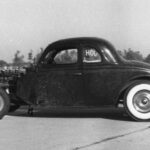 A black and white photo of a Drag Racing hot rod car.