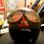 A motorcycle helmet adorned with goggles, evoking the exhilaration of drag racing, strategically placed on top of a sturdy table.