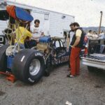 A group of people working on a drag racing car.