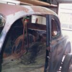 An old drag racing car tucked away in a garage.