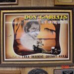 A framed poster of Don Garrett, a legendary figure in drag racing, proudly displayed on a wall.