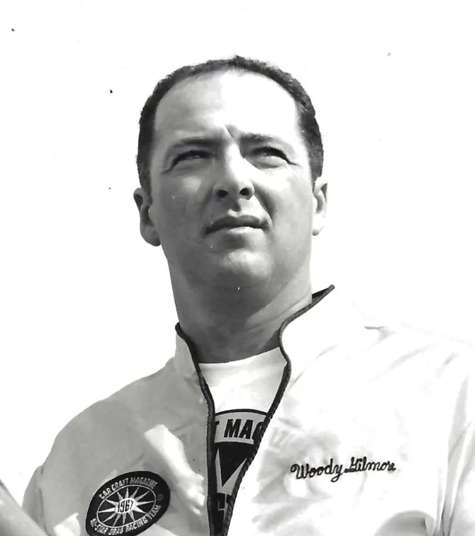 A black and white photo of a man holding a tennis racket.