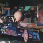 A picture of a drag car with a man driving it, showcasing thrilling Drag Racing action.