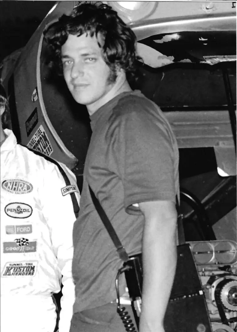 Young man with curly hair, vintage racing scene.