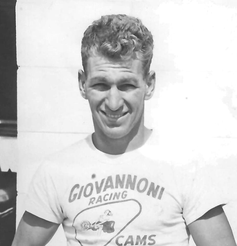 Young man smiling in racing T-shirt.