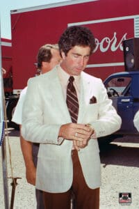 Man in suit checking his wristwatch outdoors.