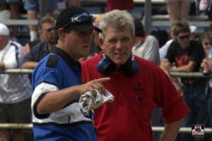 Two men discussing at a motorsport event.