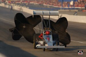 Drag race car with deployed parachutes.