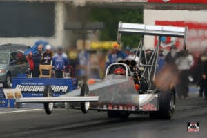 Dragster racing on a track, wheels lifted.
