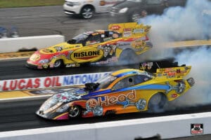Two drag racing cars speeding on track.