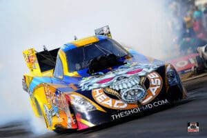 Colorful drag racing car with smoky background.