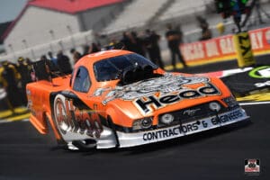 Orange drag racing car on a track.