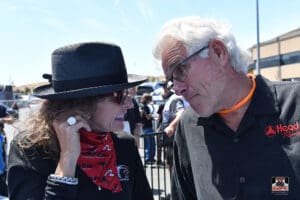 Two people conversing at an outdoor event.