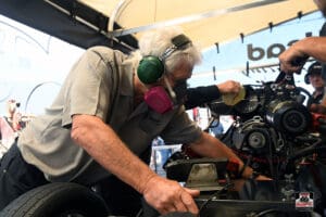 Mechanic working on a racing car engine.