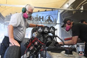 Men working on a drag racing engine.