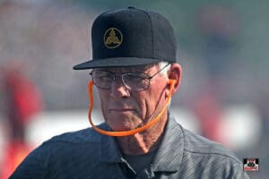 Man wearing hat and glasses with strap.