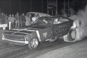 Vintage drag racing car performing burnout.