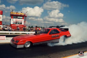 Red drag racing car at starting line.