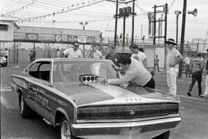 Man working on vintage racing car engine.