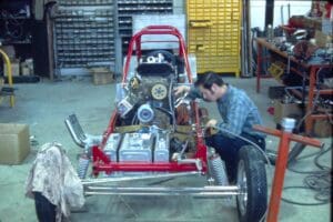 Mechanic working on race car engine.