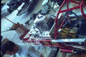 Race car chassis and engine in workshop.