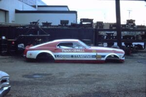 Red and white drag racing car parked.