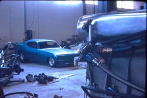 Blue car in a garage with engine.
