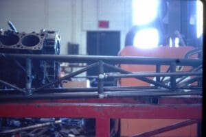 Engine block on metal frame in workshop.