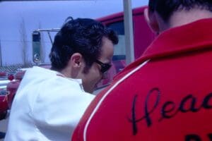 Two men wearing jackets near a truck.