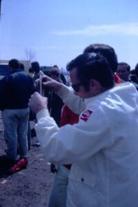 Man in white jacket examining an object.