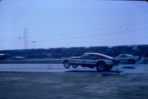 Drag racing cars speeding on track.