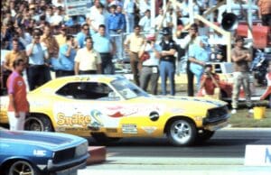 Yellow race car at drag racing event.