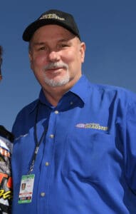 Man in blue shirt and black cap.