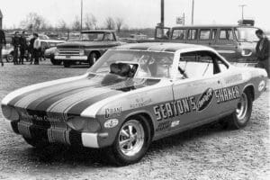 Vintage drag racing car in a parking lot.