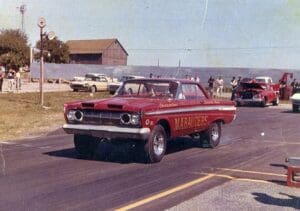 Vintage drag race car on starting line.
