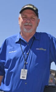 Man in blue shirt and black cap.