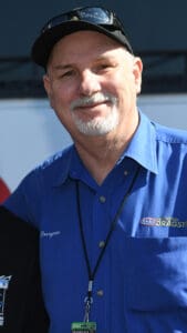Man in blue shirt and black cap.
