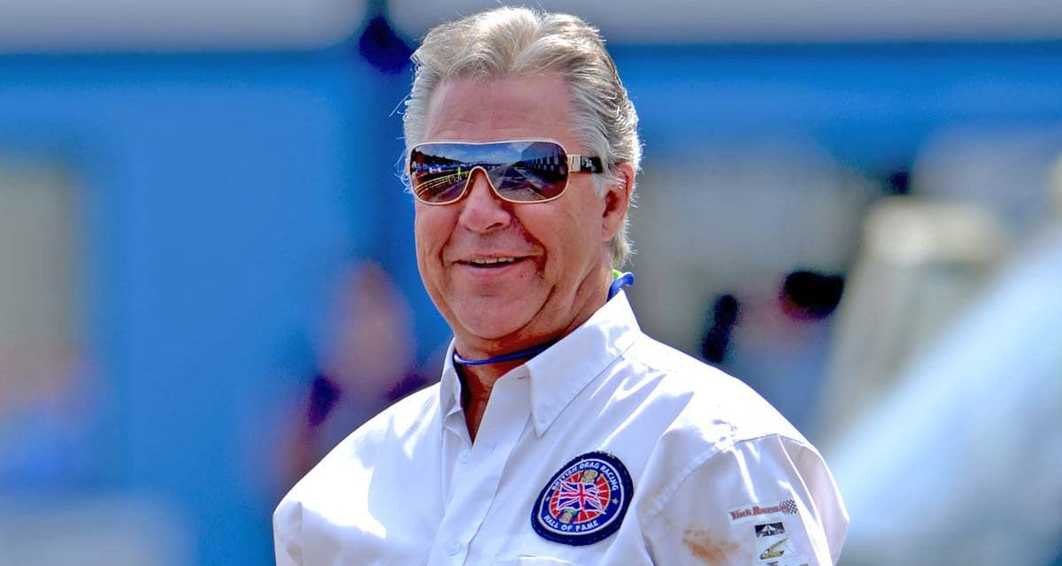 Man in sunglasses wearing a white shirt.