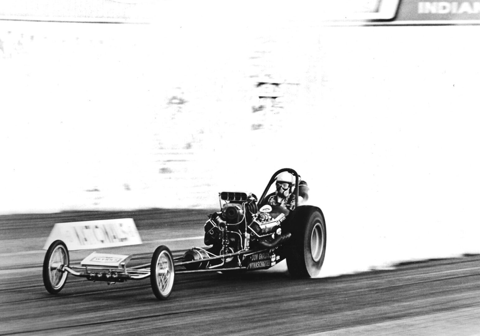 A black and white photo capturing the intensity of drag racing.