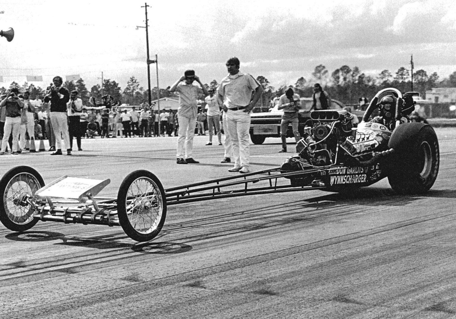 A black and white photo capturing the exhilarating rush of a man engaged in drag racing.