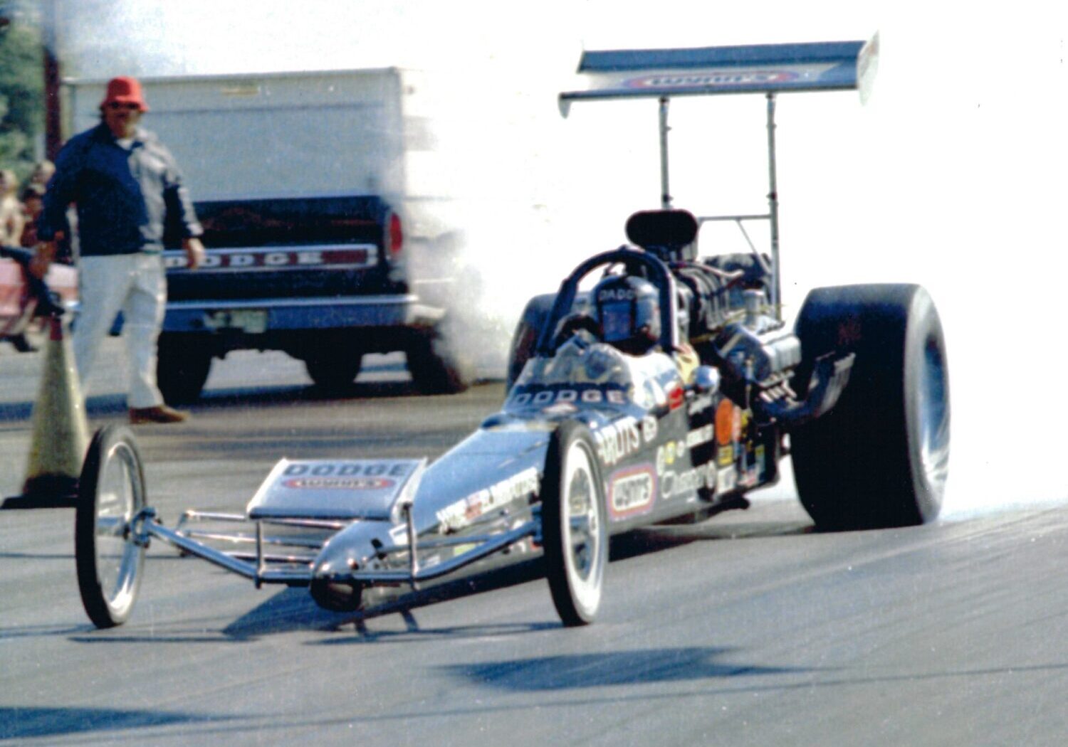 A man participating in a drag race behind the wheel of a powerful drag car.